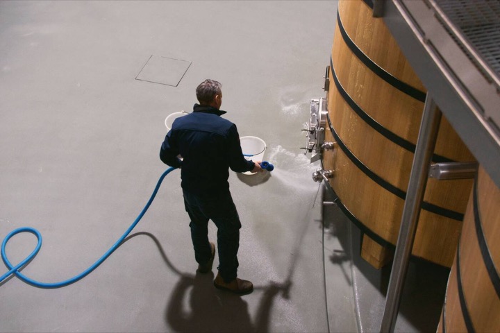 Personne travaillant sur une cuve de fermentation